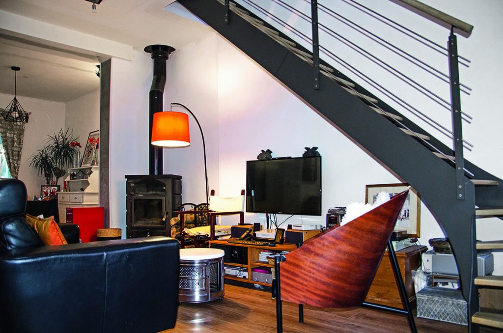 Salon à la déco familiale et escalier en métal